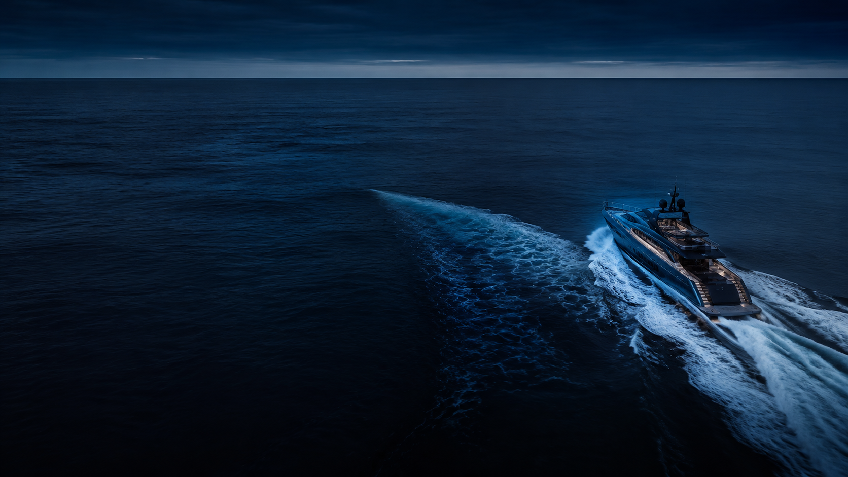 A motor yacht crossing open water at blue hour